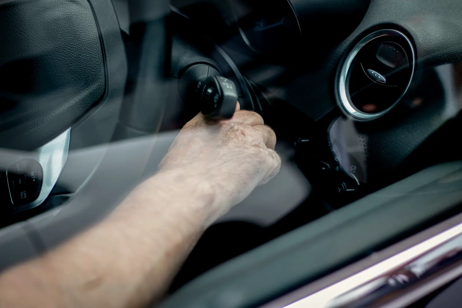 A driver's hand starting a vehicle