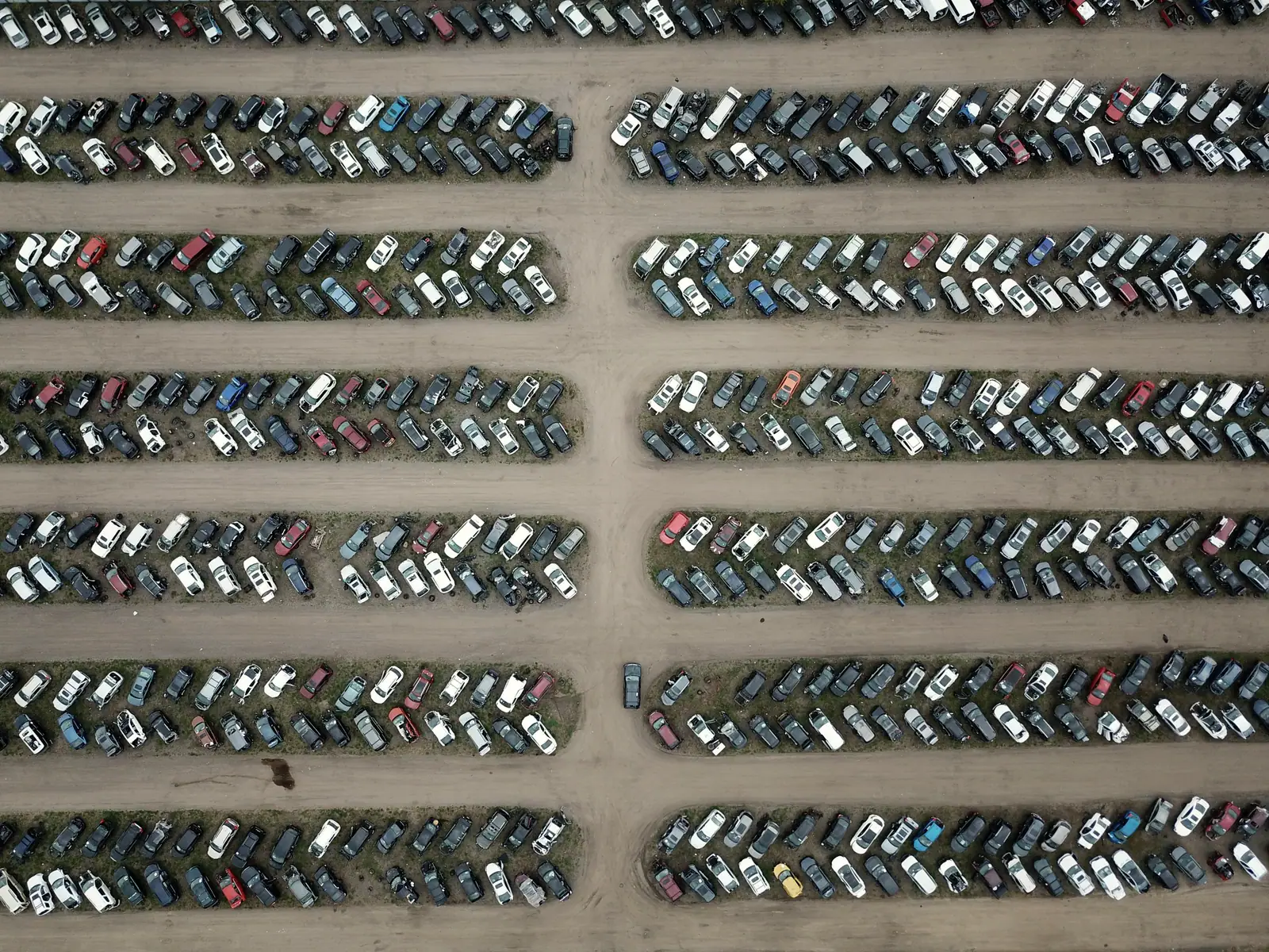 Rows of vehicles on a large dealer lot, seen from above